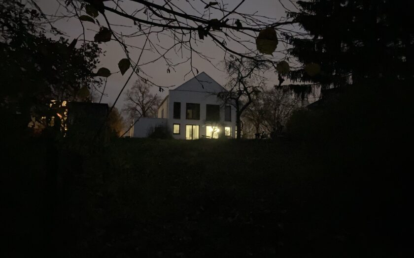 Haus mit erleuchteten Fenstern im Dunkeln