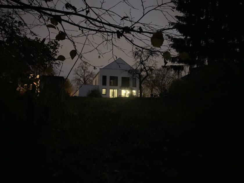 Haus mit erleuchteten Fenstern im Dunkeln