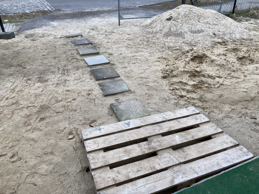 Provisorischer Weg aus Gehewegplatten und Palette